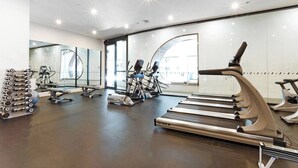 A modern gym with treadmills, weight machines, and free weights. - Orianna - Stylish Designer Pad *WiFi Park Gym Pool (South Yarra)
