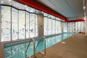 Una piscina con pannelli in vetro e una scala in metallo.