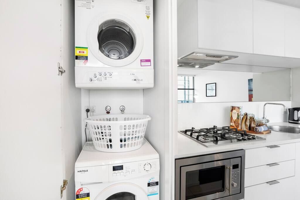 A compact kitchen with a built-in washer and dryer, a gas stove, and a microwave.