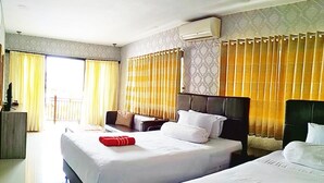 A hotel room with two beds, a sofa, a TV, and a balcony. - Jos & Hanny Homestay (Batu)