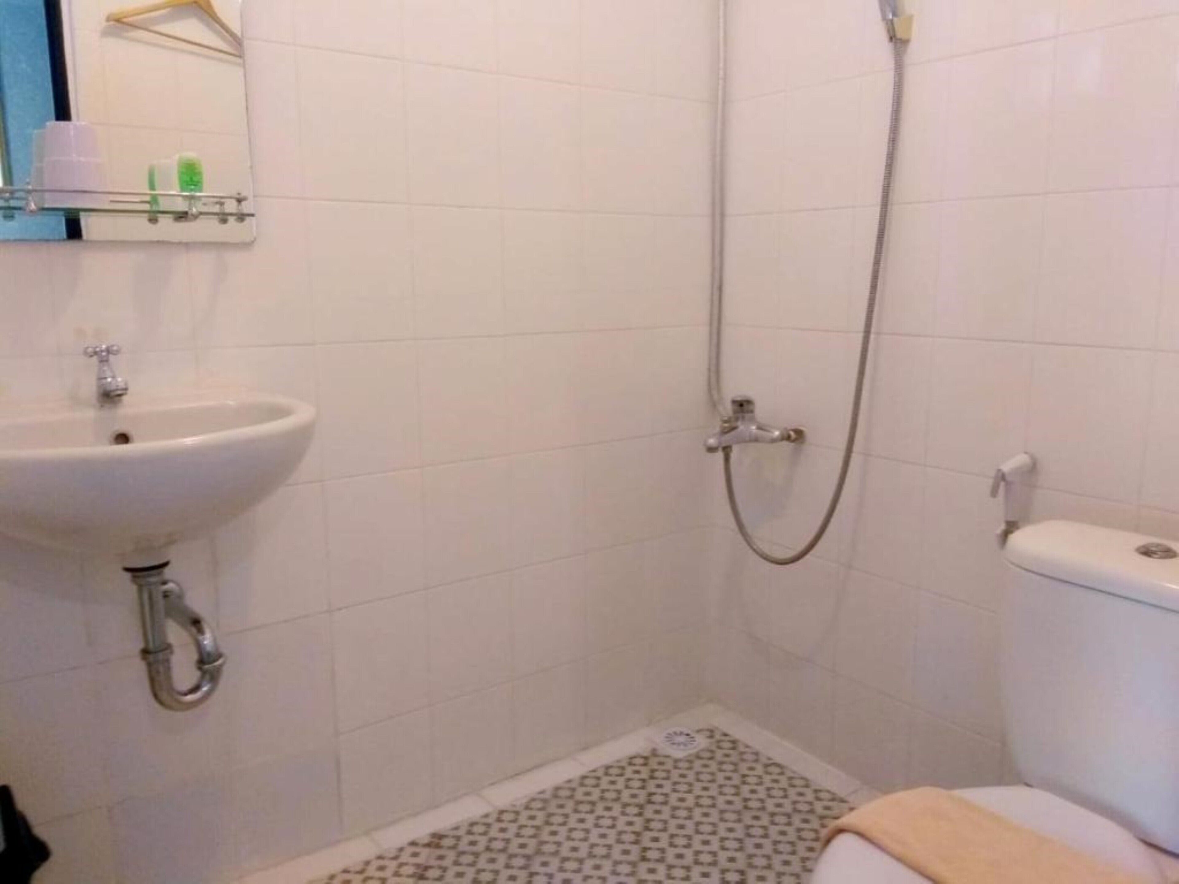 A bathroom with a sink, toilet, and shower.