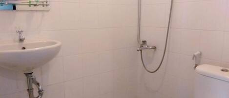 A bathroom with a sink, toilet, and shower.