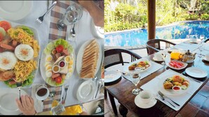 A dining table set for two with a variety of dishes, including rice, eggs, and vegetables, and a view of a swimming pool in the background. - Jos & Hanny Homestay (Batu)