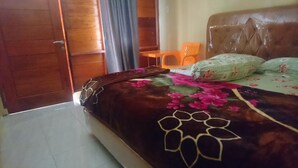 A bedroom with a bed, a chair, and a wooden door.