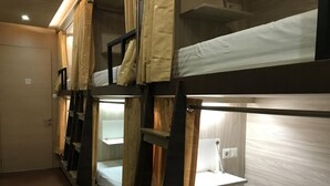 A row of bunk beds with attached desks and a small window. - The Colour Hostel (Pontianak)