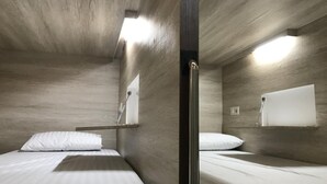 A compact room with two beds, a wooden ceiling, and a small window. - The Colour Hostel (Pontianak)