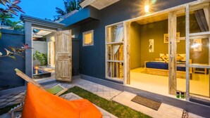 A modern bedroom with a large sliding glass door, a bed, and a small window. - Kawans Inn Lembongan (Lembongan Island)