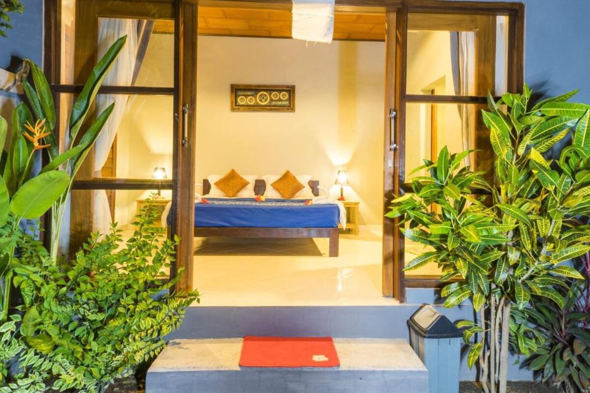 A room with a bed, pillows, and a wall-mounted sign.