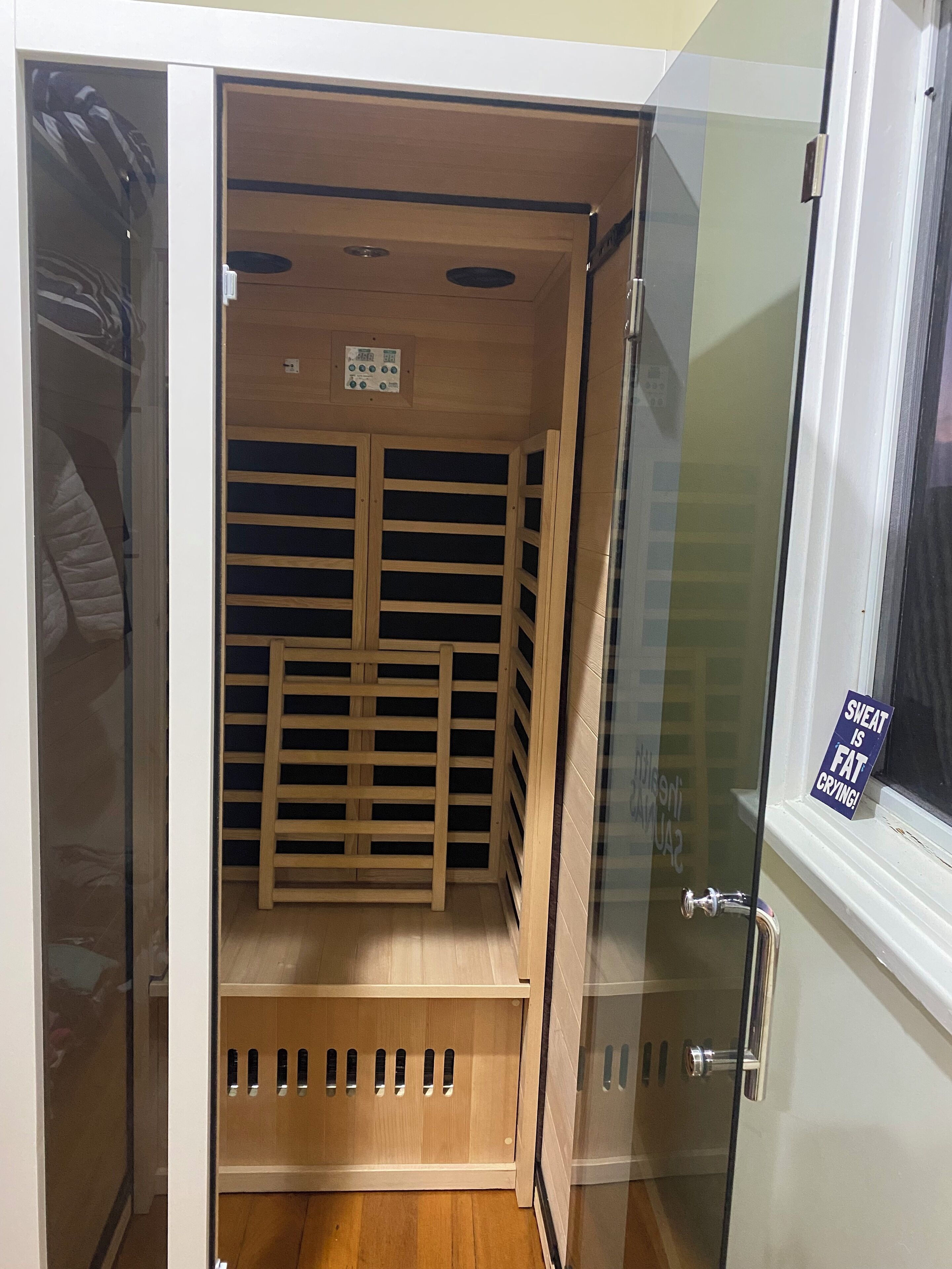 Ein begehbarer Kleiderschrank mit Holzböden und einer Bedienkonsole an der Decke.