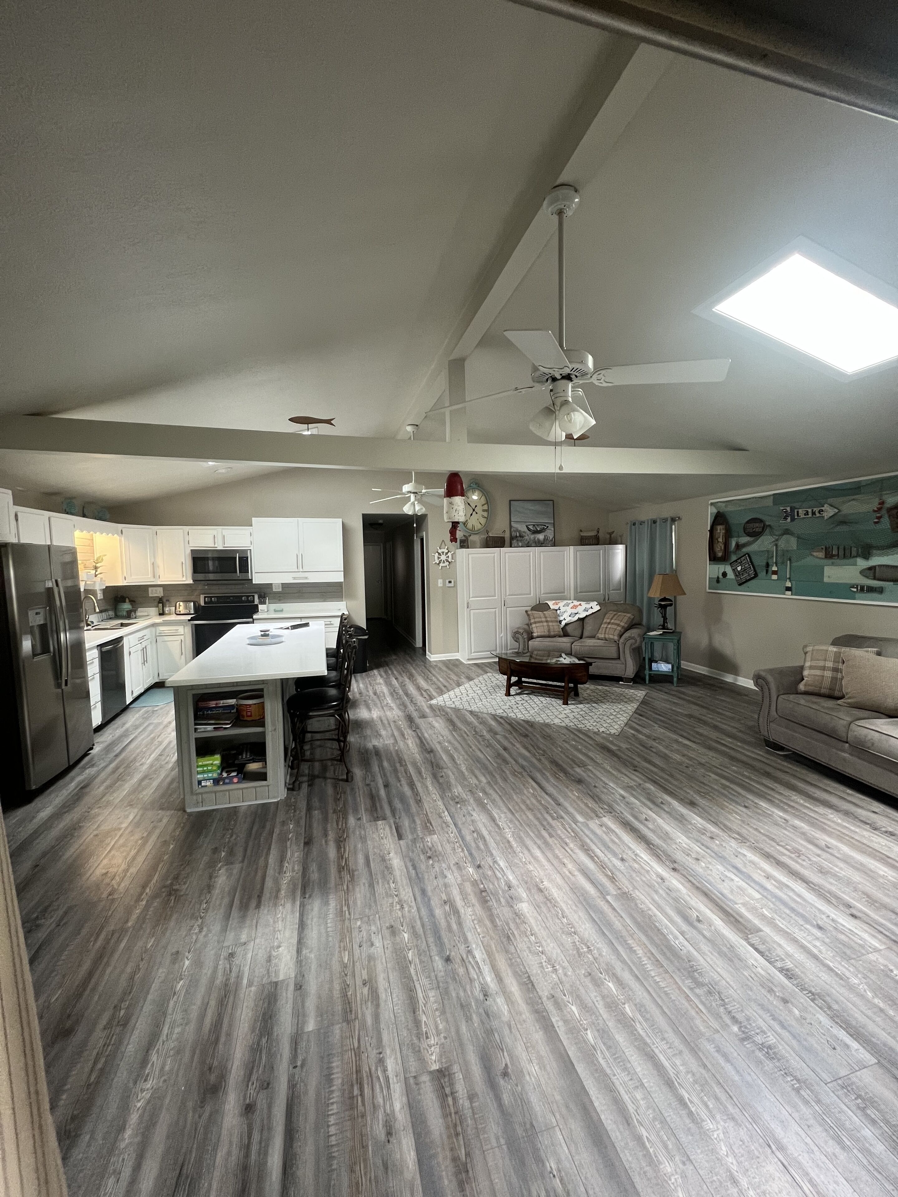 A spacious living area with a kitchen, dining area, and a large window.