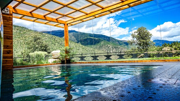 A pool with a view of mountains and a wooden pergola. - The Postcard Dewa Thimphu (Thimphu)