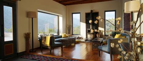 Un salón amplio con techo alto, ventanas grandes y chimenea.
