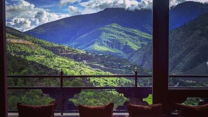 A room with a large window overlooking a mountainous landscape. - The Postcard Dewa Thimphu (Thimphu)