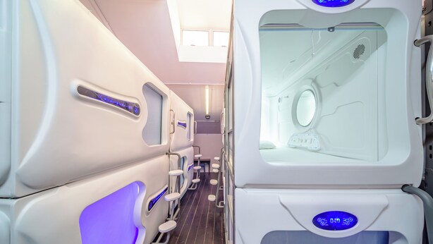 A row of private massage rooms with individual control panels and a large window. - K Space Inn 569 - Hostel (Singapore)