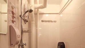 A compact bathroom with a sink, toilet, and shower. - K Space Inn 569 - Hostel (Singapore)