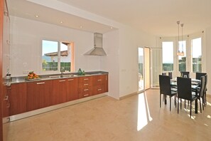 A modern kitchen with wooden cabinets, a stainless steel sink, and a large window.