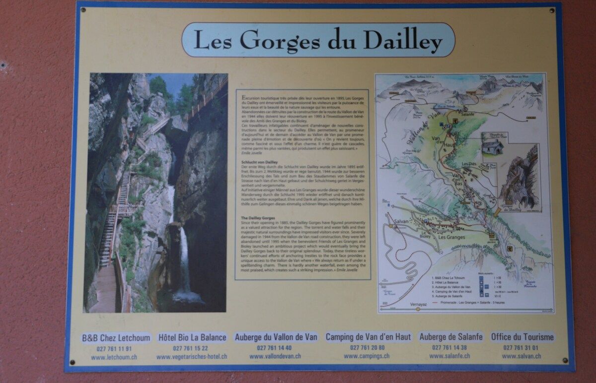 Un cartel con información sobre Les Gorges du Dailey, que incluye un mapa y una foto de una cascada.