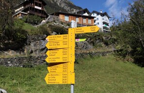 Un cartel indicador con destinos y tiempos de viaje.
