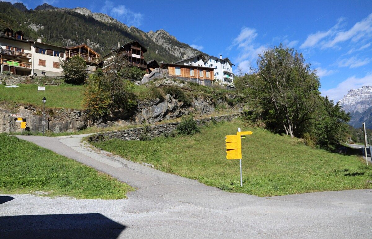 Eine Bergstraße mit Fußweg und Verkehrsschild.