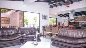 A modern living room with leather sofas, a white coffee table, and a dining area with wicker chairs. - 6 Bedroom 7 bath AC, Hot tub Balcony Poblado. No guest fees no register guests. (Medellín)