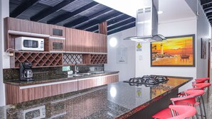 A kitchen with a granite countertop, a microwave, a coffee maker, and a gas stove. - 6 Bedroom 7 bath AC, Hot tub Balcony Poblado. No guest fees no register guests. (Medellín)