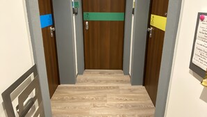 A hotel corridor with wooden doors, a green sign, and a metal handrail. - Holiday Home - Home Holiday - Cozy House Matera - Blue House - VERY CENTRAL (Matera)