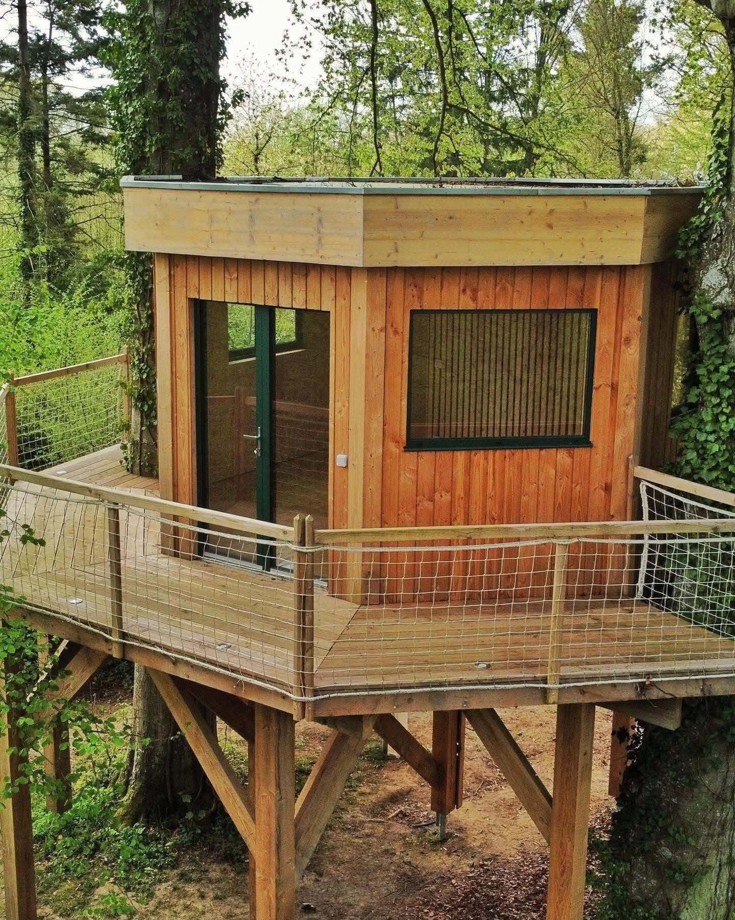 A wooden observation tower with a glass door and a metal railing.