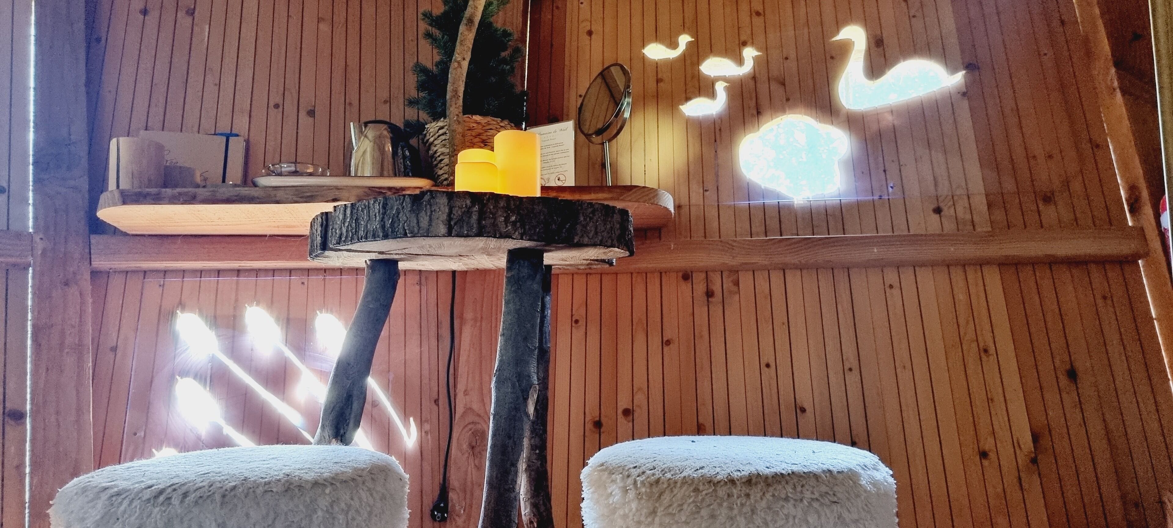 Een houten interieur met een plank waarop een ananas, een kaars en een menukaart staan.