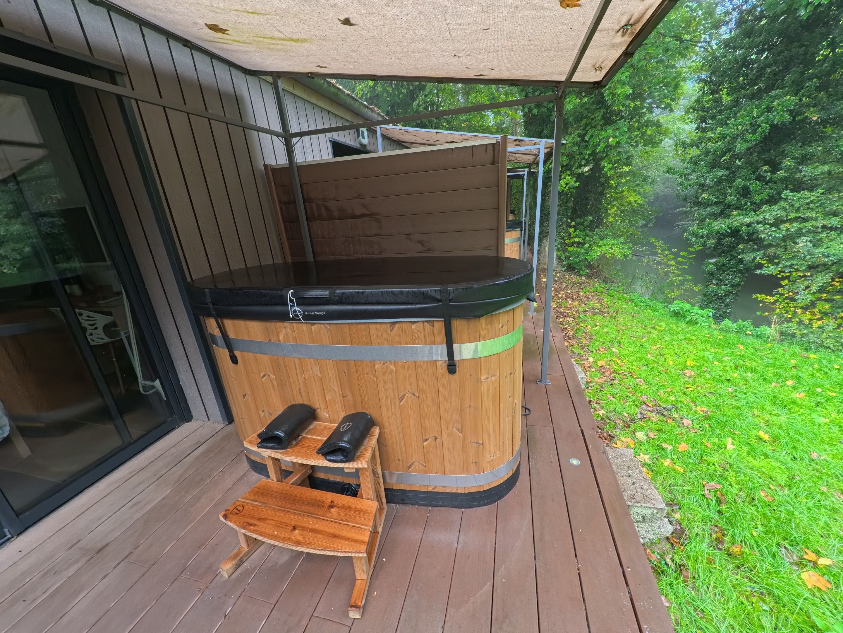 A wooden sauna with a bench and two benches on a wooden deck.