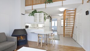 Une cuisine moderne dotée d’un îlot central, de planchers en bois et d’un espace en mezzanine avec une rambarde en bois.