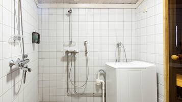 Een badkamer met een douche, toilet en wastafel.