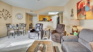 A living room with a sofa, two armchairs, a coffee table, and a dining area with a table and chairs. - Phoenix Group Getaway, 3 Mi to State Farm Stadium! (Phoenix)