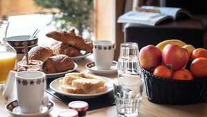 A breakfast table with croissants, bread, fruit, and beverages. - CGH Le Lodge des Neiges (Tignes)