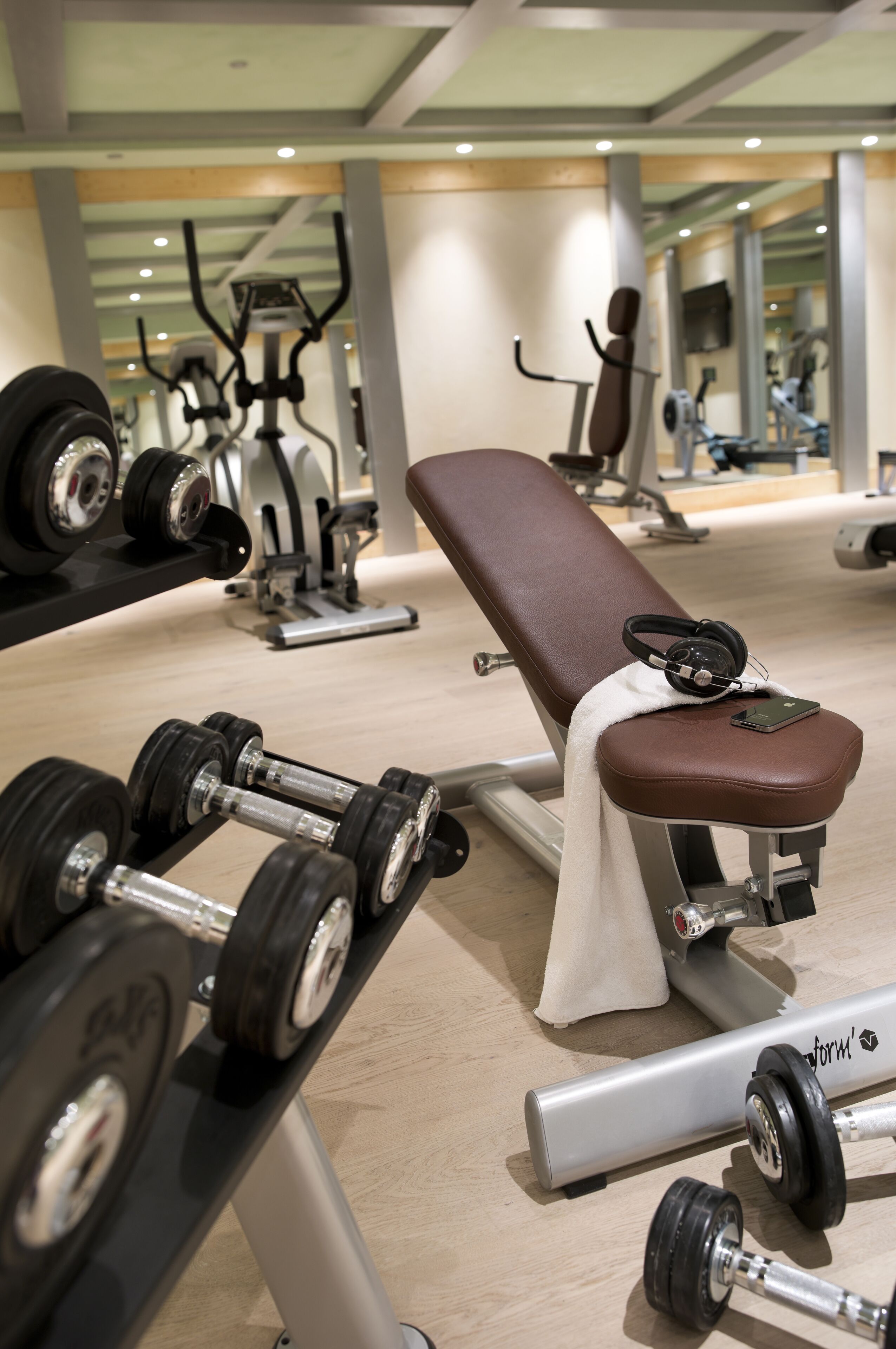 A gym with exercise equipment, including dumbbells and a bench.