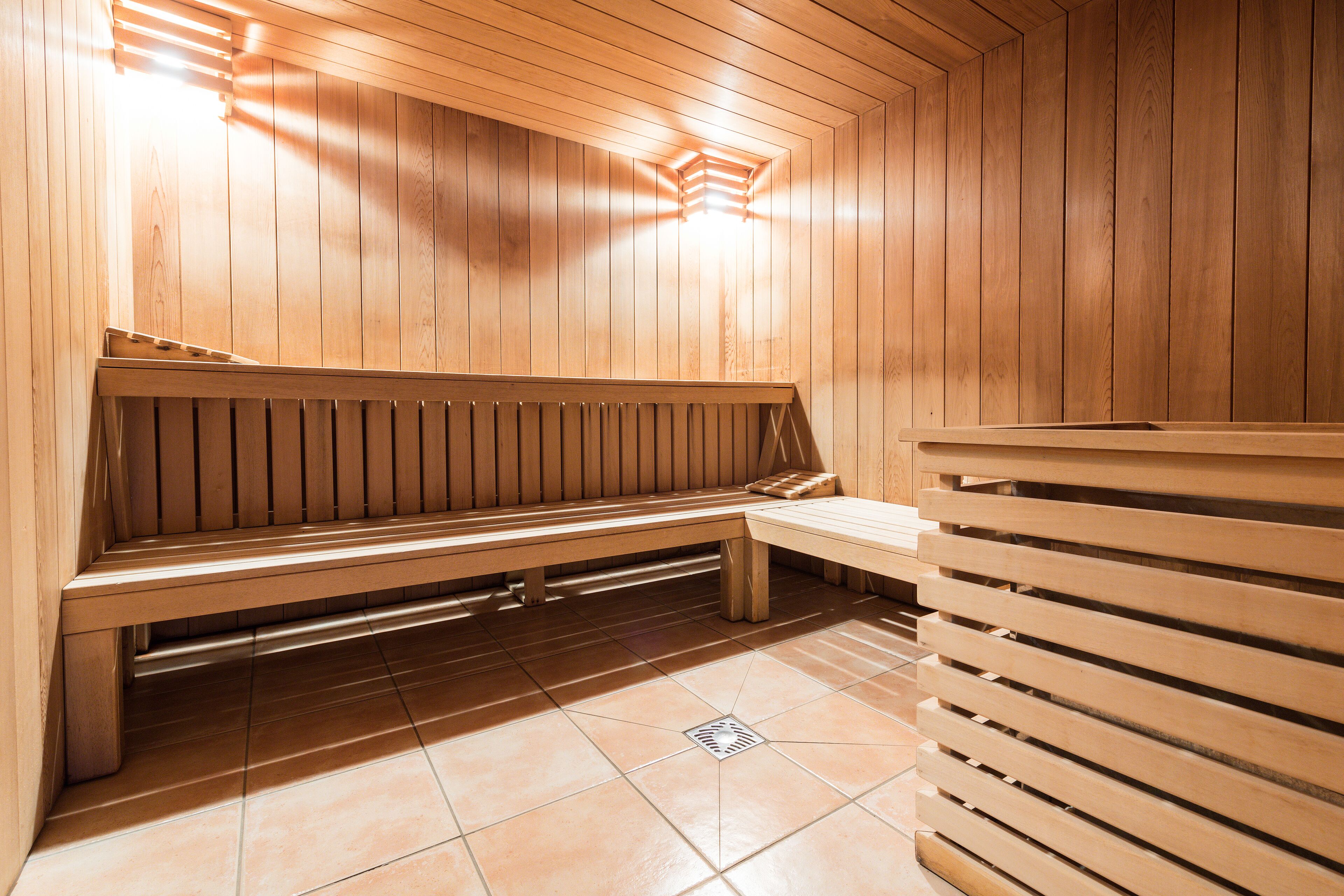 A sauna with wooden benches and slatted seating.