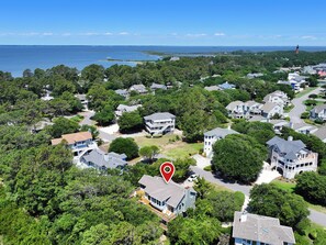 A residential area with houses surrounded by trees and a view of the ocean. - Oceanside, 815 ft to Beach Access, Corolla Light Amenities, 715, Seven Ships (Corolla)