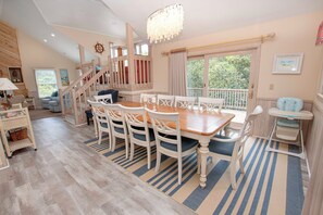 Relax in a spacious living area with a high ceiling, large windows, and a cozy seating area.