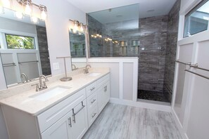 Enjoy a spacious bathroom with a dual sink vanity and glass-enclosed shower area.