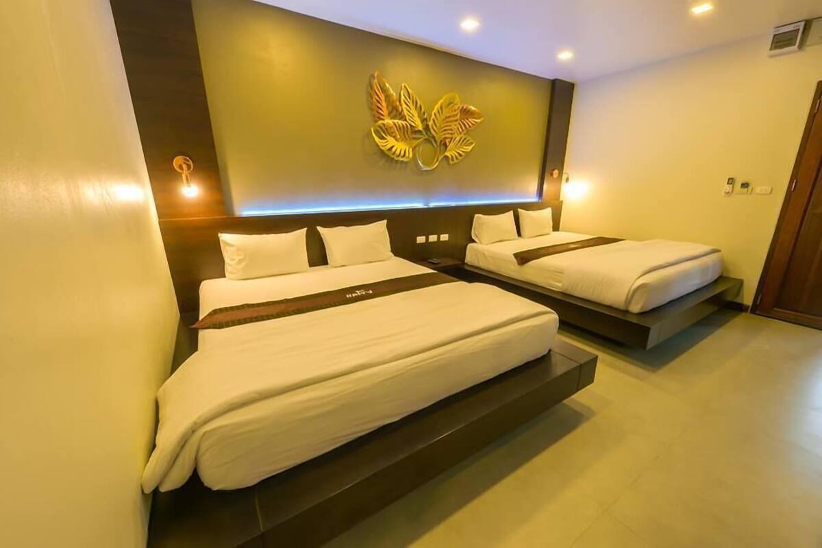 A hotel room with two beds, a decorative wall piece, and a modern design.