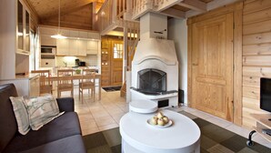 A cozy living area with a fireplace, a sofa, and a dining table.