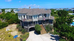 A multi-story house with a balcony, a flag, and a flagpole.