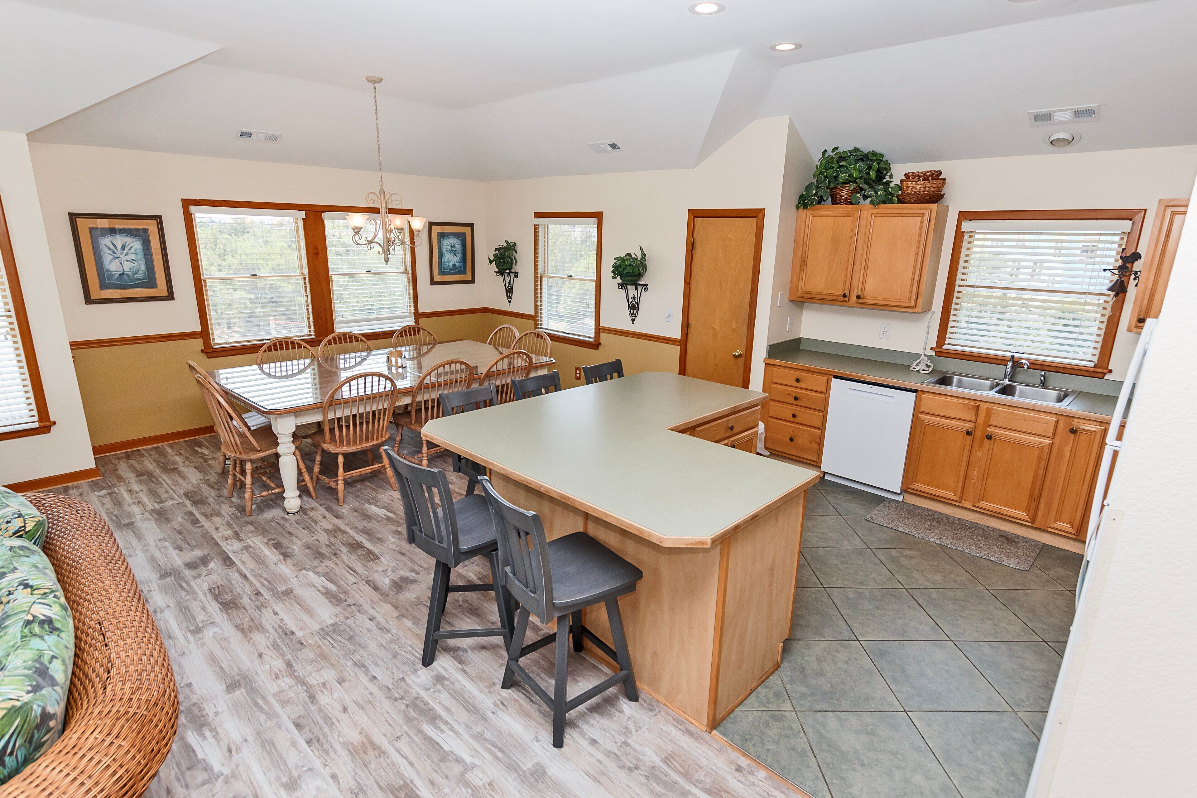 A spacious kitchen with a large island, wooden cabinets, and a dining area with a table and chairs.