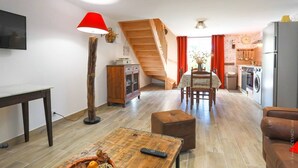 Un appartamento moderno con zona pranzo, cucina e una scala che conduce a un livello superiore.
