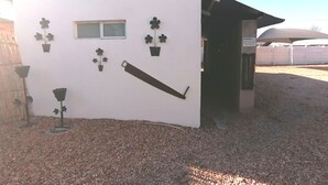 Un edificio con fachada blanca, una ventana y varias plantas en macetas en la pared.