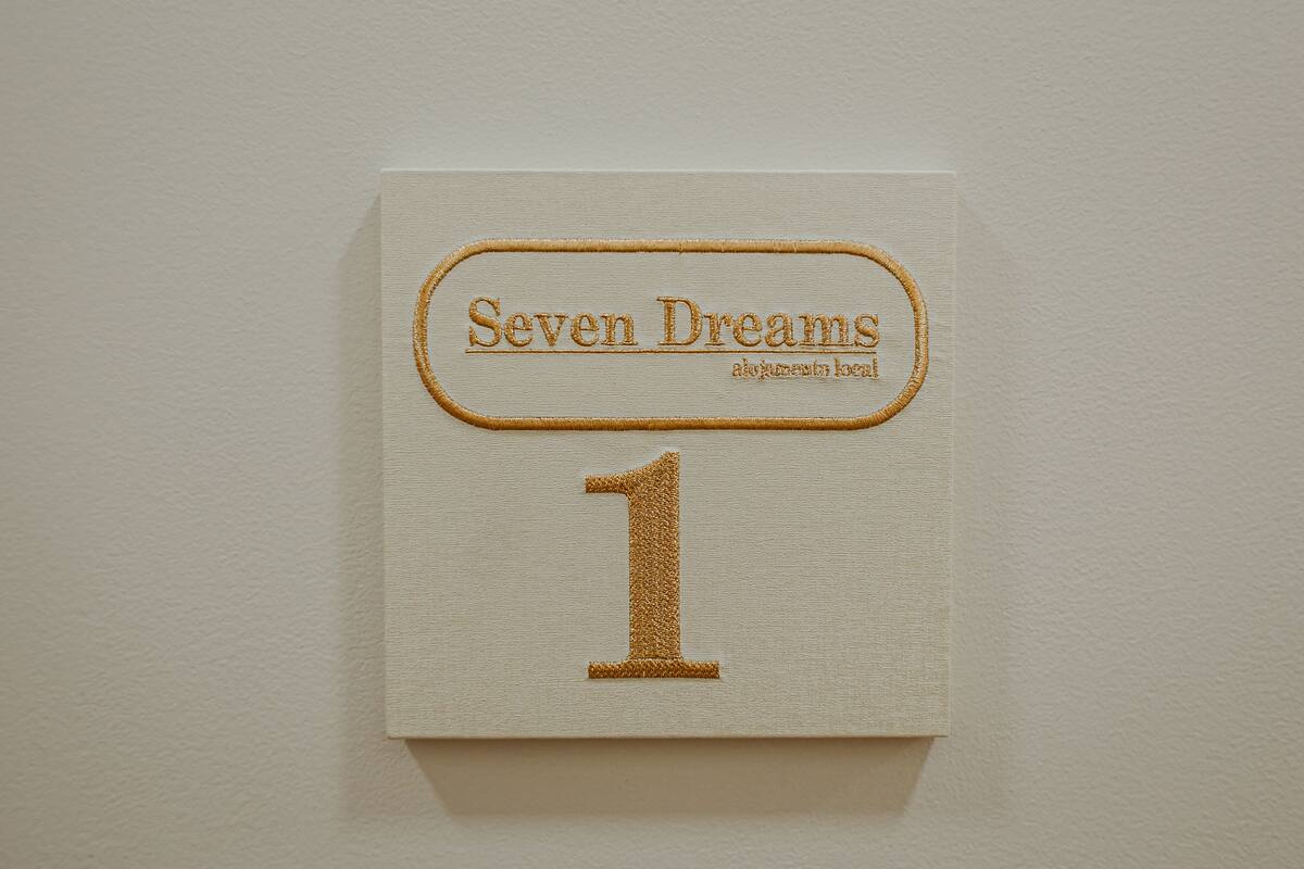 A sign with the text "Seven Dreams" and the number "1".