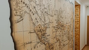 A wall with a large, detailed map featuring a compass and a ship's wheel. - Seven Dreams Suites (Lisbon)