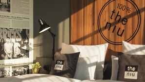 A neatly made bed with pillows labeled "the niu" and a lamp beside it. - Holiday Inn - the niu, Bricks Hamburg by IHG (Hamburg)
