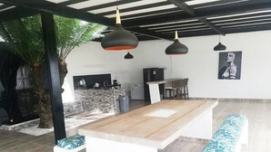 A modern kitchen with a central island, pendant lighting, and a dining area with benches. - CARMEN DE APICALA A FANTASY SITE ...! (Anapoima)
