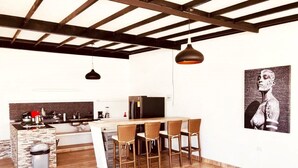 A modern kitchen with a central island, bar seating, and a large painting on the wall. - CARMEN DE APICALA A FANTASY SITE ...! (Anapoima)