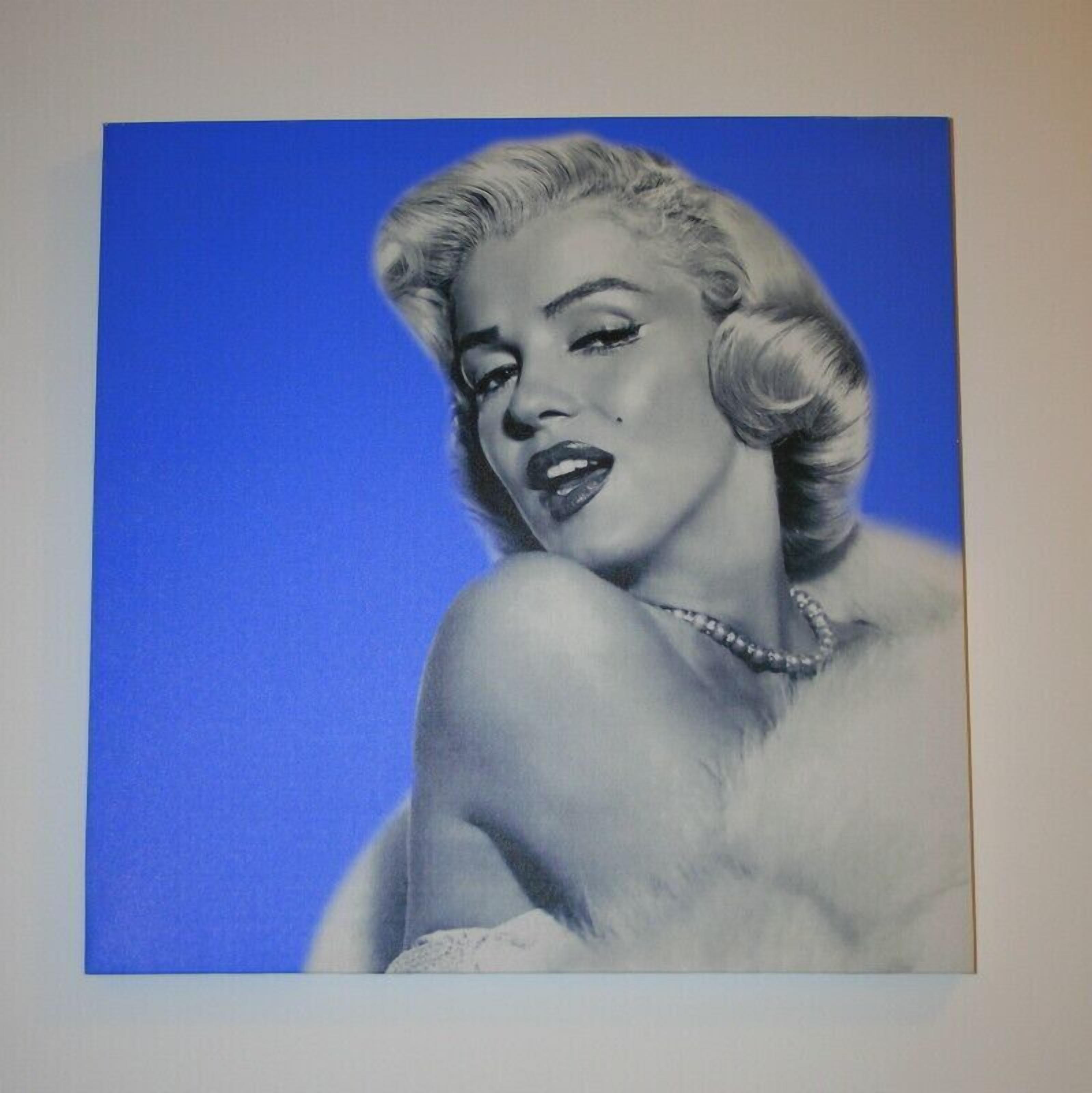 A portrait of a person with a blue background.